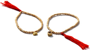 Tiny bracelets, made of gold or rudraksha beads with small symbols (made often of 24k gold).