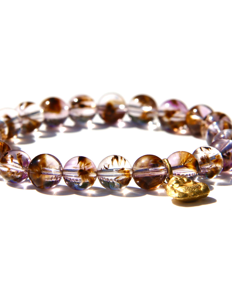 Stretch bracelet, beads made of Cacoxenite Amethyst.   Each beads has wisps of golden cacoxenite. The beads are crystal clear and full of Light. This is truly a magnificent strandSmall 18k gold laughing Buddha.