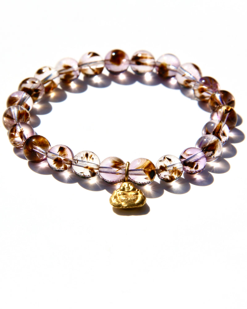 Stretch bracelet, beads made of Cacoxenite Amethyst.   Each beads has wisps of golden cacoxenite. The beads are crystal clear and full of Light. This is truly a magnificent strandSmall 18k gold laughing Buddha.