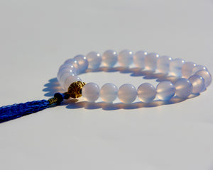 The Healers bracelet, blue chalcedony.  With a 24k gold bead and blue cotton tassel.  Blue chalcedony helps create the Sacred voice. It also has strong color healing abilities.  Stretch bracelet. Length: 18 cms.