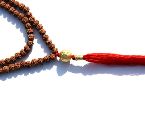 Rudraksha beads mala necklace with a 24k gold bead.  It is written on the gold bead: Om Mani Padme Om.  This is stage 2 of Rudhraksha beads ' growth. The Rudraksha beads in the minis collection are smoother and the clear separation lines have not appeared yet..  It is being said that wearing a Rudraksha beads mala cancels your karma!