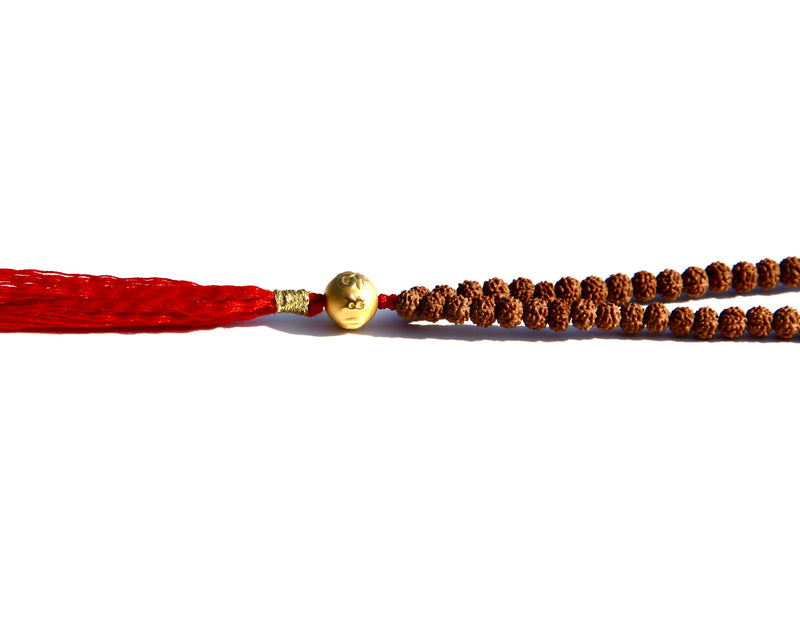 Rudraksha beads mala necklace with a 24k gold bead.  It is written on the gold bead: Om Mani Padme Om.  This is stage 2 of Rudhraksha beads ' growth. The Rudraksha beads in the minis collection are smoother and the clear separation lines have not appeared yet..  It is being said that wearing a Rudraksha beads mala cancels your karma!