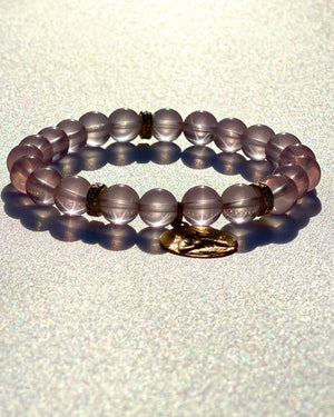 Healer's Bracelet. Beads made of Mozambique star rose quartz. Mozambique star rose quartz is an embodiment of the Love frequency, it opens the Heart chakra deeper until it becomes a Christed Heart.  It is of great help to Lightworkers and those working with energies.  Mozambique star rose quartz, three: 18k yellow gold spacers with white diamonds and an 18k yellow gold medal of the Divine feminine with hands on the Christed Heart.