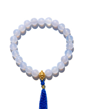 The Healers bracelet, blue chalcedony.  With a 24k gold bead and blue cotton tassel.  Blue chalcedony helps create the Sacred voice. It also has strong color healing abilities.  Stretch bracelet. Length: 18 cms.