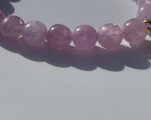 Kunzite is an emblem of the peach and lavender rays of Light, and radiates with unconditional Love. It vibrates at a frequency similar to Lady Guanyin's Love energy.  Kunzite beads bracelet with an 18k gold beads and on the opposite side a miniature treasure box, with magickal dusts inside.   The miniature treasure box is made of 18k yellow gold and white diamonds. It has a small Vajra on top of it.  Stretch bracelet