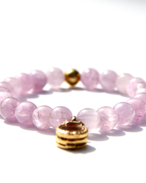 Kunzite is an emblem of the peach and lavender rays of Light, and radiates with unconditional Love. It vibrates at a frequency similar to Lady Guanyin's Love energy.  Kunzite beads bracelet with an 18k gold beads and on the opposite side a miniature treasure box, with magickal dusts inside.   The miniature treasure box is made of 18k yellow gold and white diamonds. It has a small Vajra on top of it.  Stretch bracelet