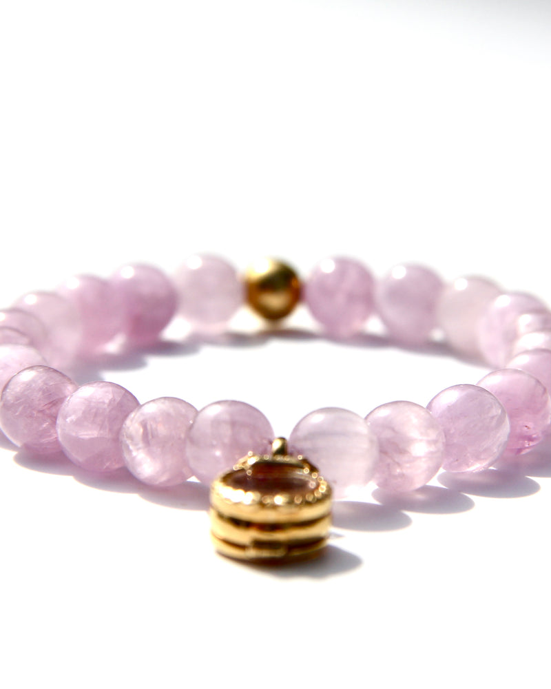 Kunzite is an emblem of the peach and lavender rays of Light, and radiates with unconditional Love. It vibrates at a frequency similar to Lady Guanyin's Love energy.  Kunzite beads bracelet with an 18k gold beads and on the opposite side a miniature treasure box, with magickal dusts inside.   The miniature treasure box is made of 18k yellow gold and white diamonds. It has a small Vajra on top of it.  Stretch bracelet