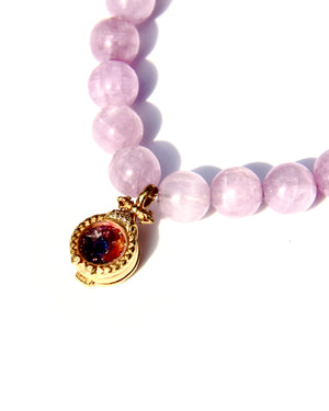 Kunzite is an emblem of the peach and lavender rays of Light, and radiates with unconditional Love. It vibrates at a frequency similar to Lady Guanyin's Love energy.  Kunzite beads bracelet with an 18k gold beads and on the opposite side a miniature treasure box, with magickal dusts inside.   The miniature treasure box is made of 18k yellow gold and white diamonds. It has a small Vajra on top of it.  Stretch bracelet